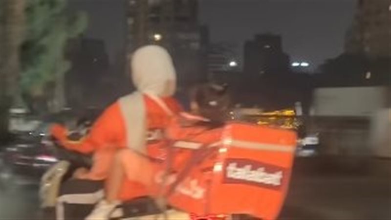 عاملة في مجال توصيل الطلبات مع طفلتيها